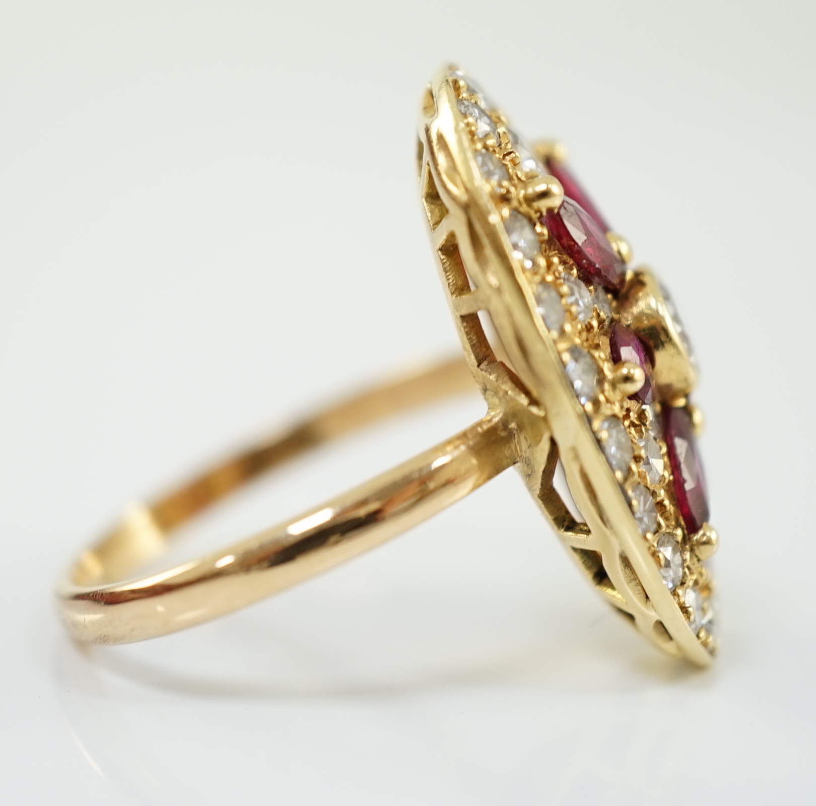 A modern gold, ruby and diamond set oval cluster ring